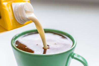 Pouring plant-based milk to a cup of coffee