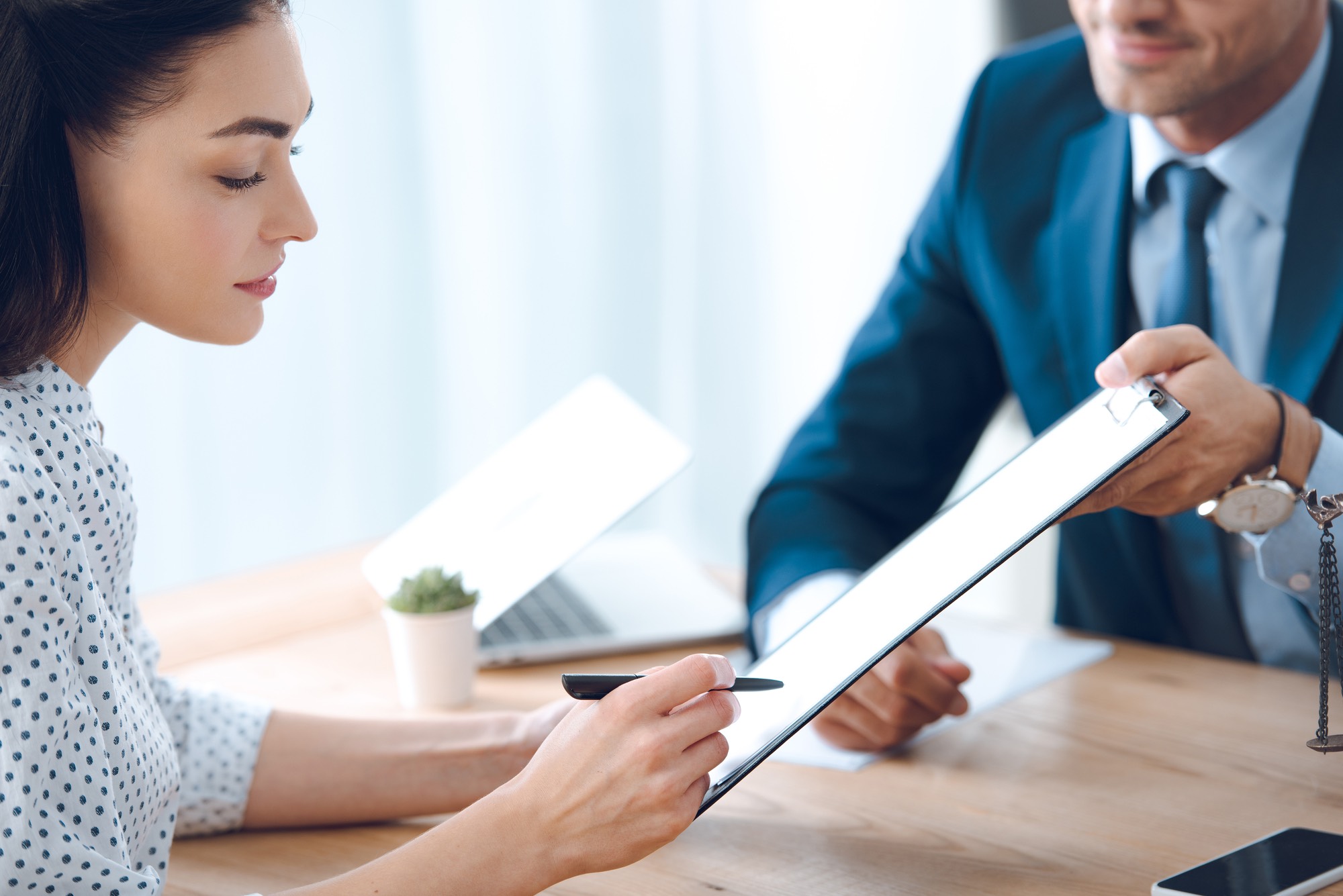 woman signing disability insurance form