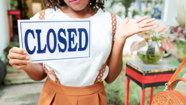 Business owner holding a closed sign amid cOVID regarding information on What Should You Know When Filing a Business Interruption Claim Letter?
