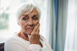 Senior woman looking concerned over the nursing home class action lawsuit filed against Lundy Manor over its lack of COVID-19 response 