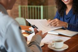 woman showing man paperwork regarding information on when to hire a long-term disability lawyer 