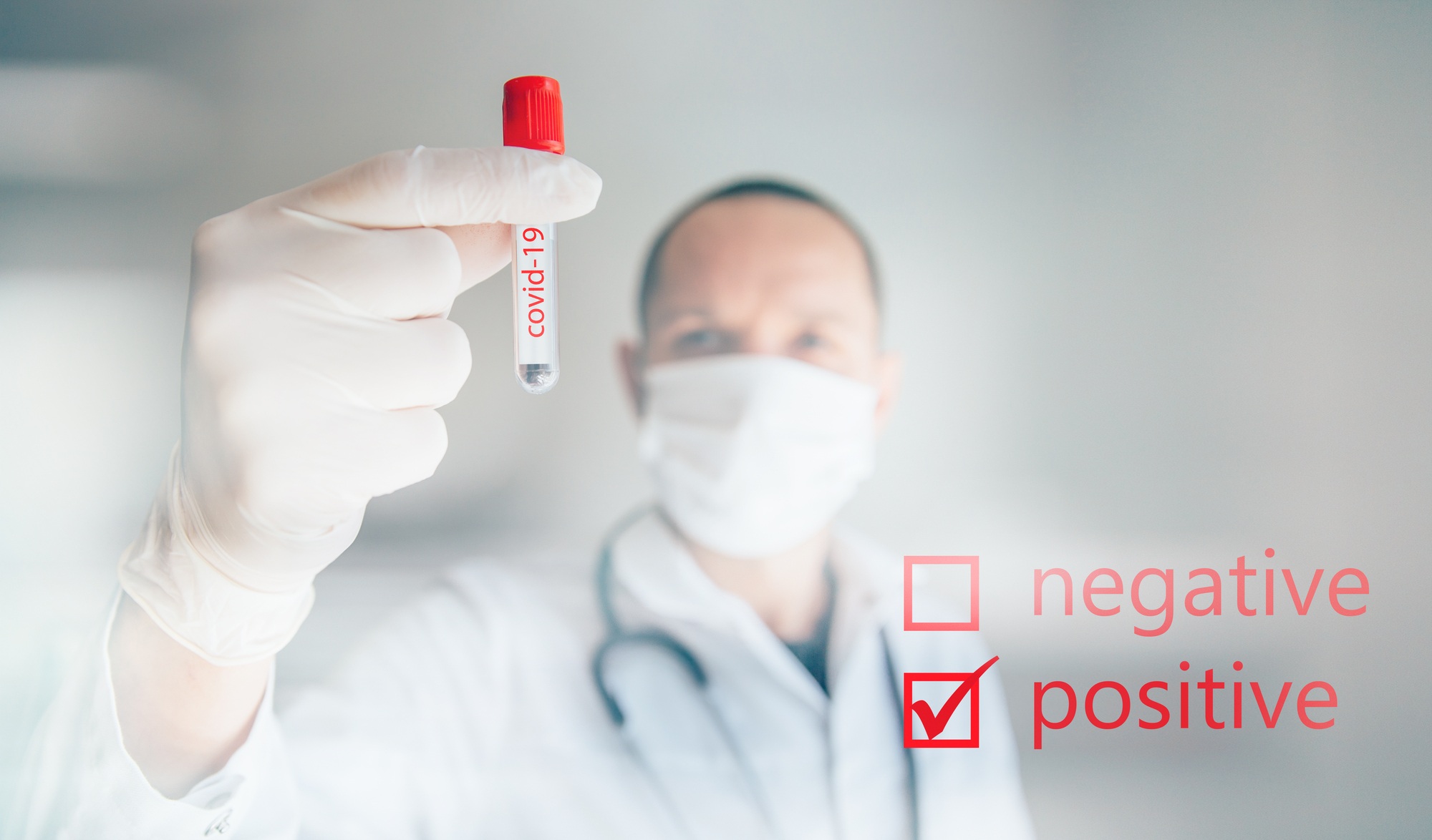 Doctor holding a positive COVID-19 labeled test tube regarding the false COVID-19 positive test results class action lawsuit to be filed against Lab