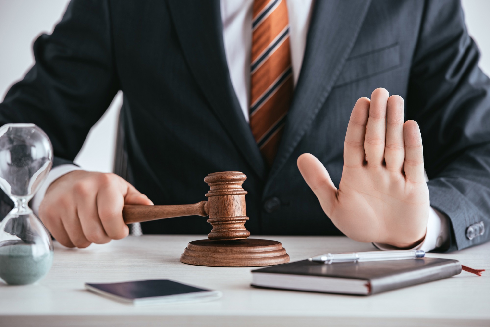 Man holding gavel with hand up regarding information on what injunctive relief is.