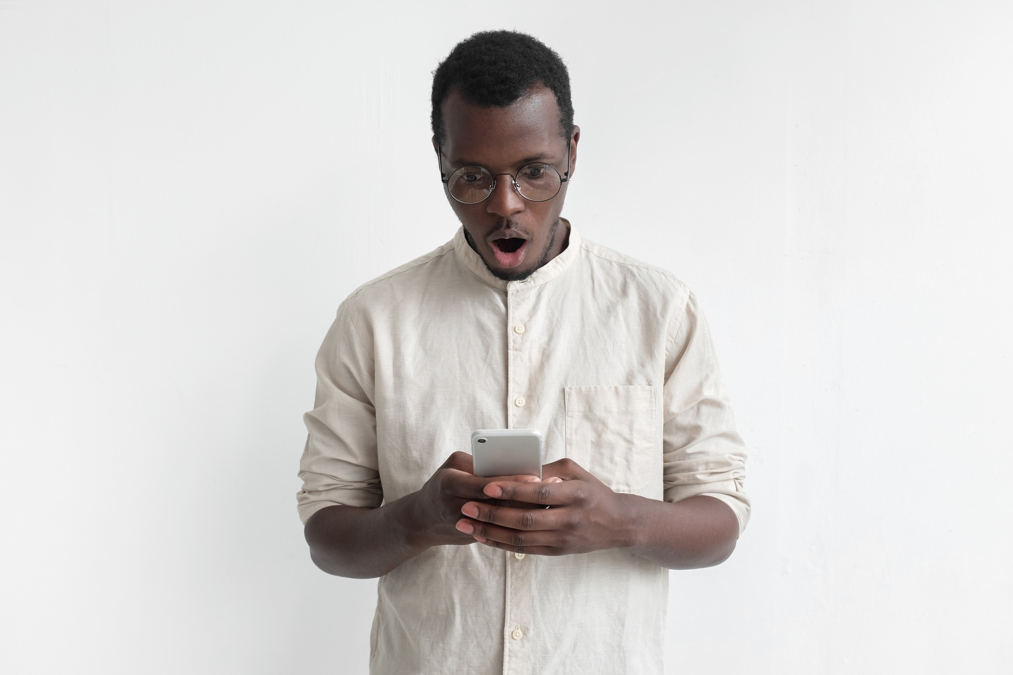Man looking shocked and upset at phone regarding the Fitness Depot data breach 