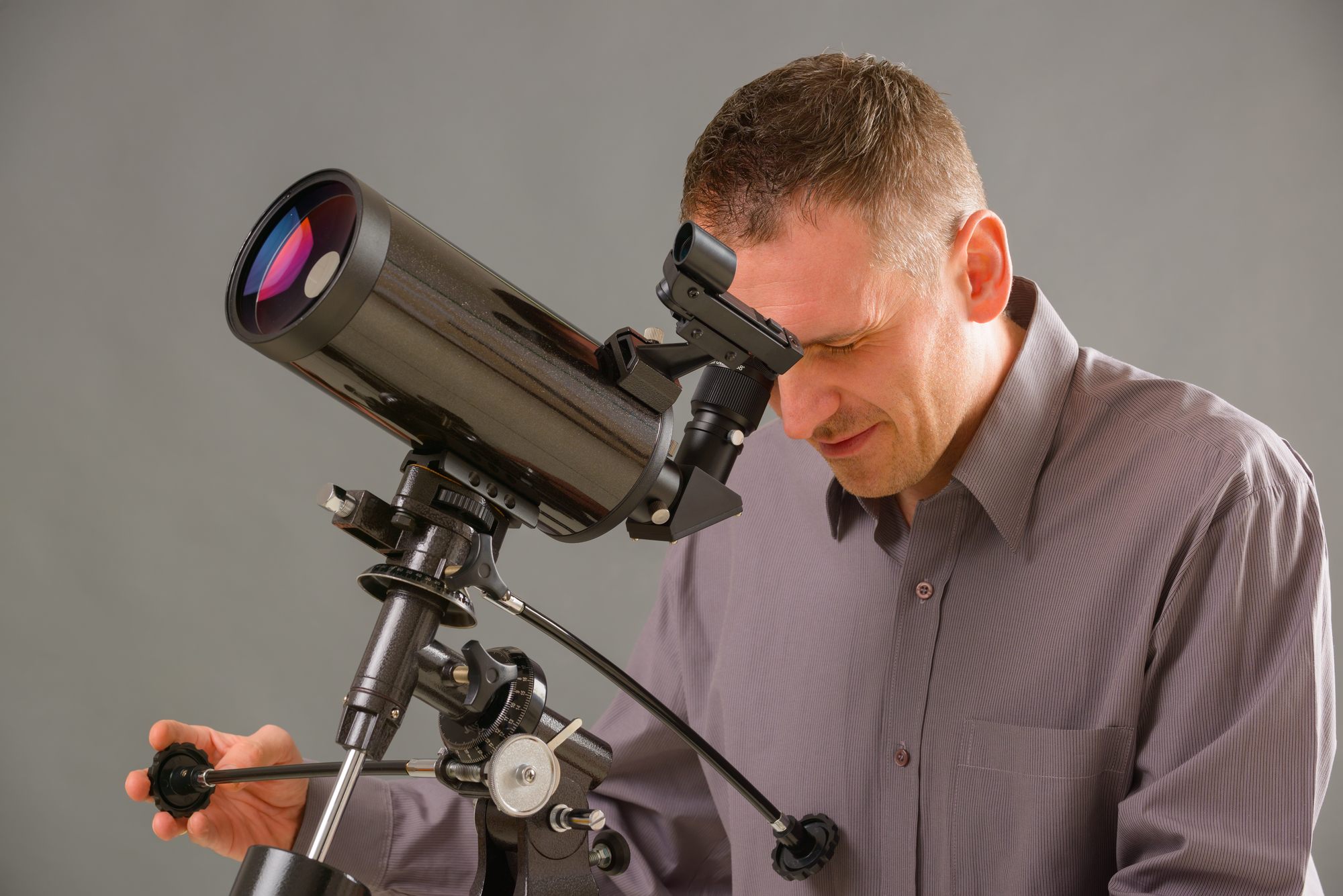 Man using telescope regarding the telescope price-fixing class action lawsuit filed