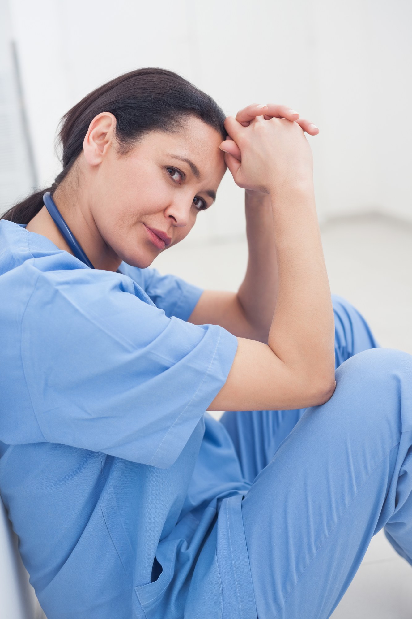 Nurse sitting on the ground regarding the seniors' home class action lawsuit alleging that the facility forced nurses to work sick with COVID-19