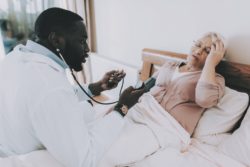 Nurse taking care of elderly woman regarding the Revera class action lawsuit over the nursing home's response to COVID-19