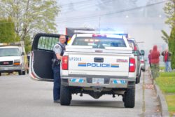 RCMP officer standing by police truck regarding the RCMP discrimination class action lawsuit expanding