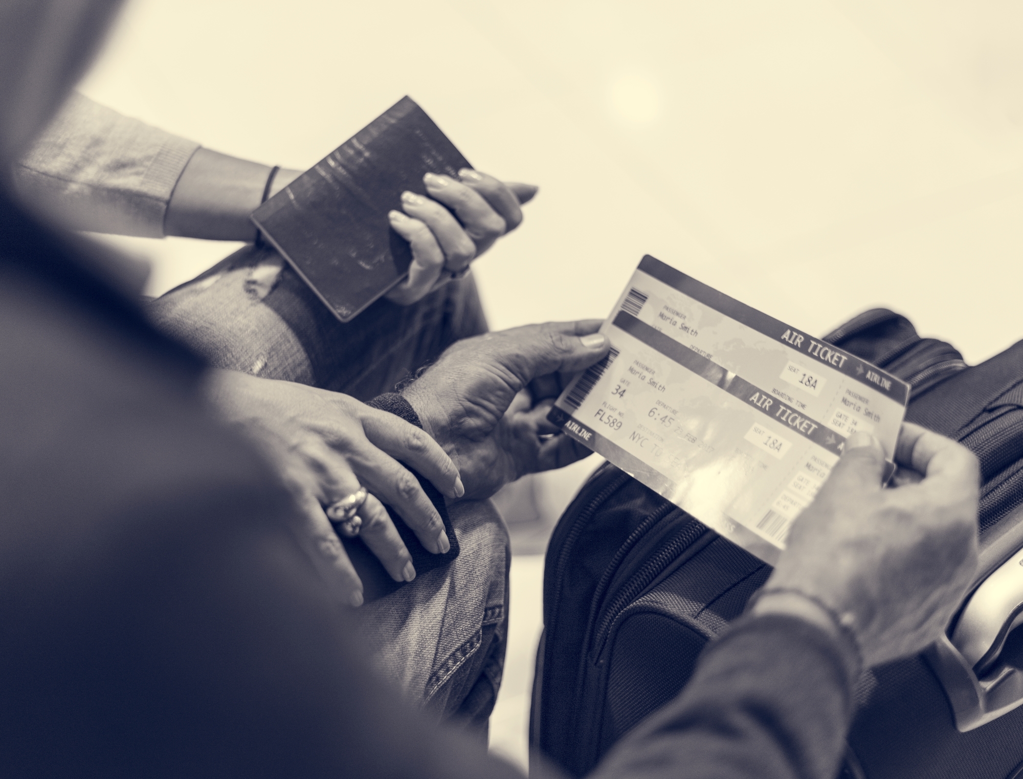 Pair of hands holding flight tickets regarding the class action filed against Air Canada over retirement benefits