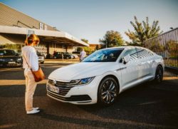Person standing in front of Volkswagen Passat regarding the Bosch emissions cheating device class action settlement 