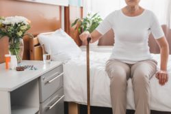 Senior woman sitting on bed regarding the nursing home neglect class action lawsuit filed against Southbridge Care Homes 