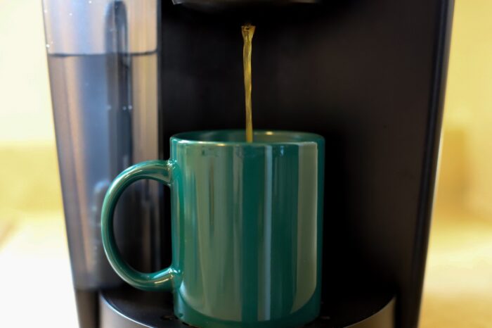 Coffee Dripping from a Brewer into a Green Mug