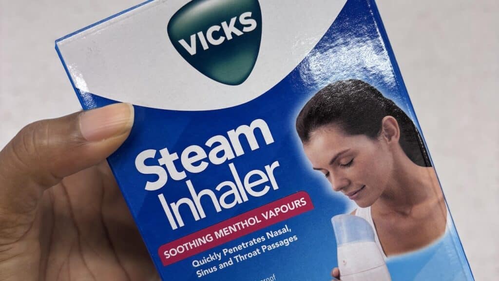 person holding a box of Vicks steam inhaler with soothing menthol vapours in a store