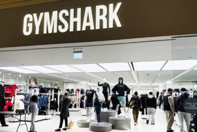Inside the Gymshark shop, shoppers browse athleticwear around mannequins and bright lighting.